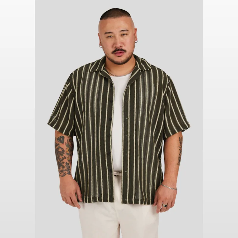 Man wearing a dark green short sleeve shirt with vertical cream stripes, featuring a cuban collar and relaxed fit.