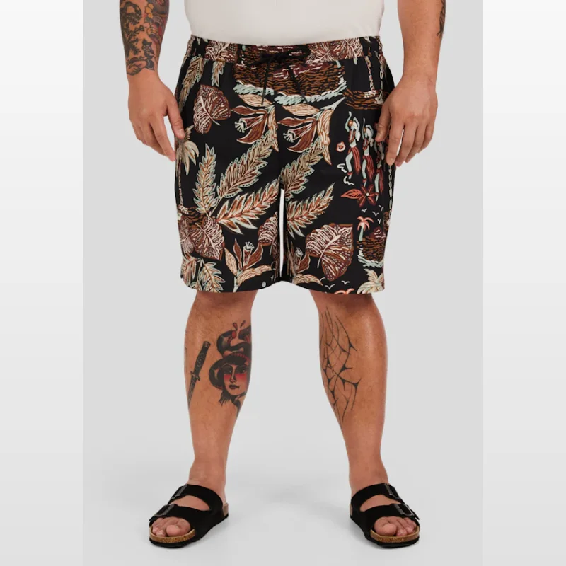 Man wearing black swim shorts with a tropical island life print featuring leaves, figures, and palm trees.