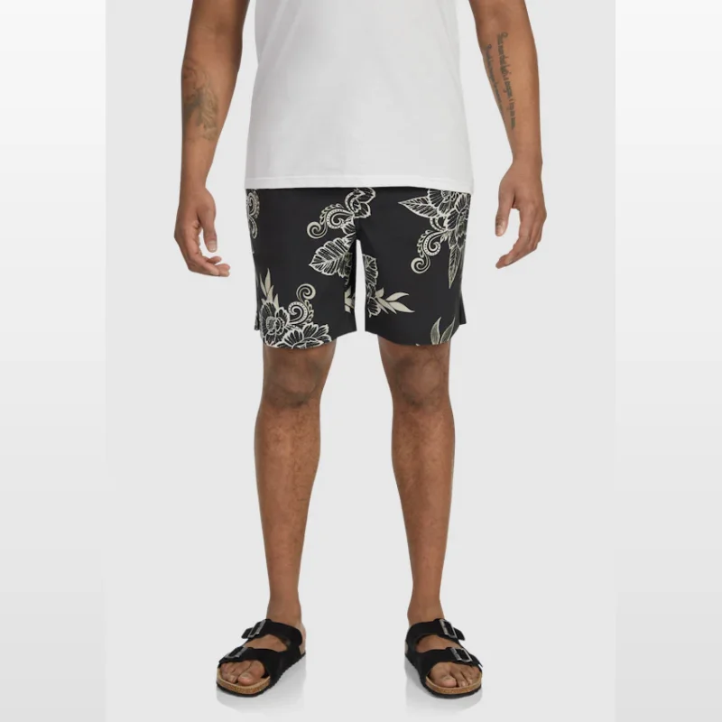 Man wearing black swim shorts with a white floral print, elasticated waistband, and above-the-knee length.