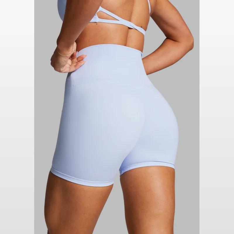 Close-up rear view of a woman wearing light blue Rockwear no front seam scrunch bum bike shorts and a matching sports bra.