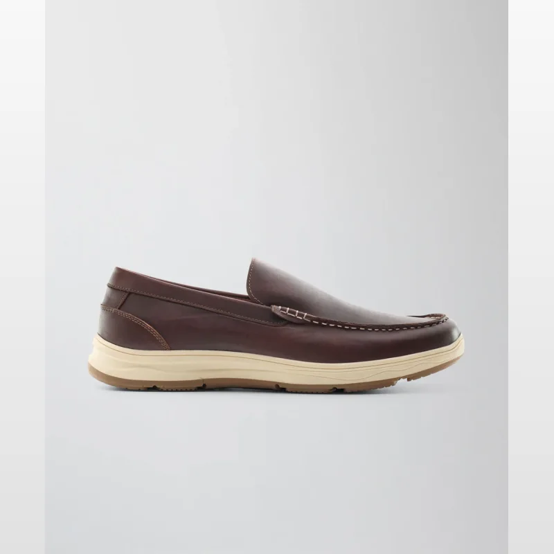Side view of a men's brown leather loafer shoe with a cream-coloured sole and white stitching details.