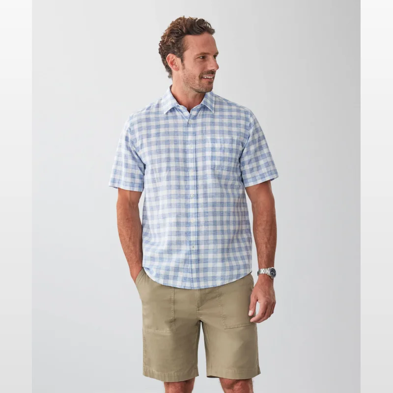 Man wearing a blue and white check short sleeve linen blend shirt with khaki shorts.