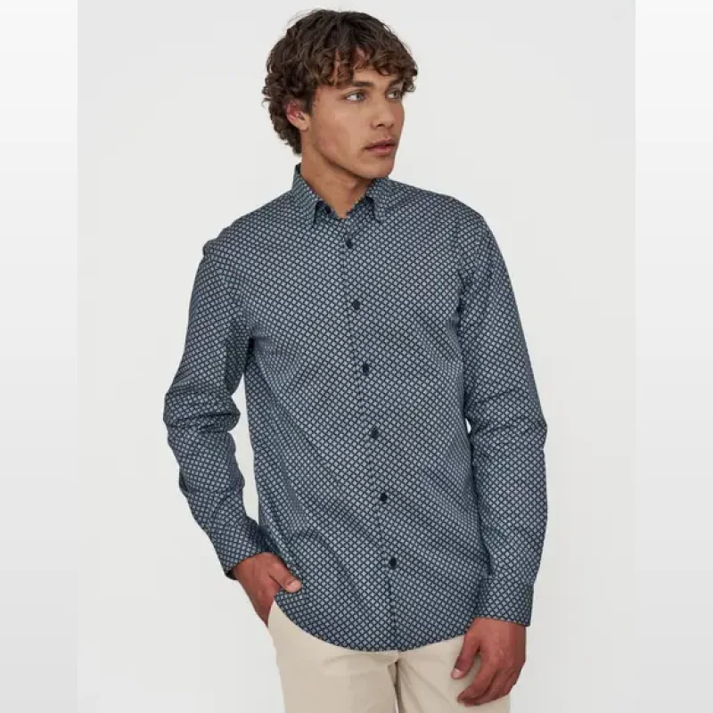 Man wearing a navy long sleeve dress shirt with a subtle geometric prism pattern.