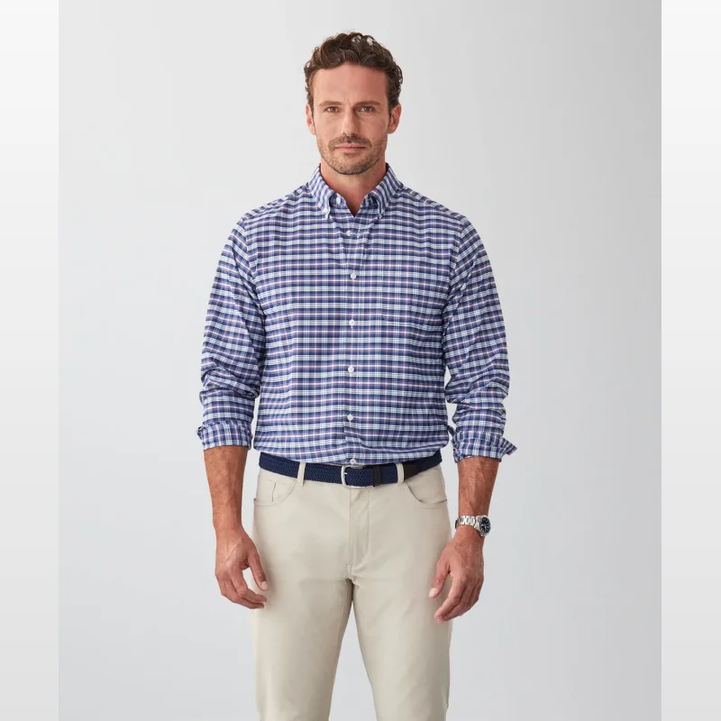 Man wearing a GAZFLEX Performance Twill Check Long Sleeve Shirt in navy with blue and red highlights, paired with beige trousers and a navy belt.