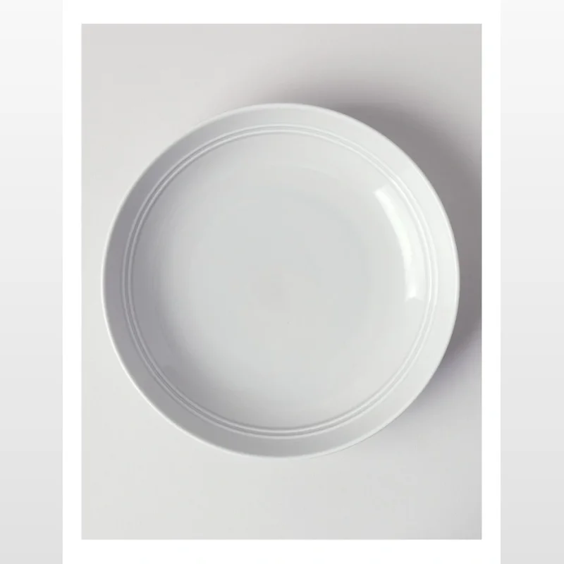 A white glazed porcelain pasta bowl with a 23cm diameter and subtle concentric ring detailing on the rim.