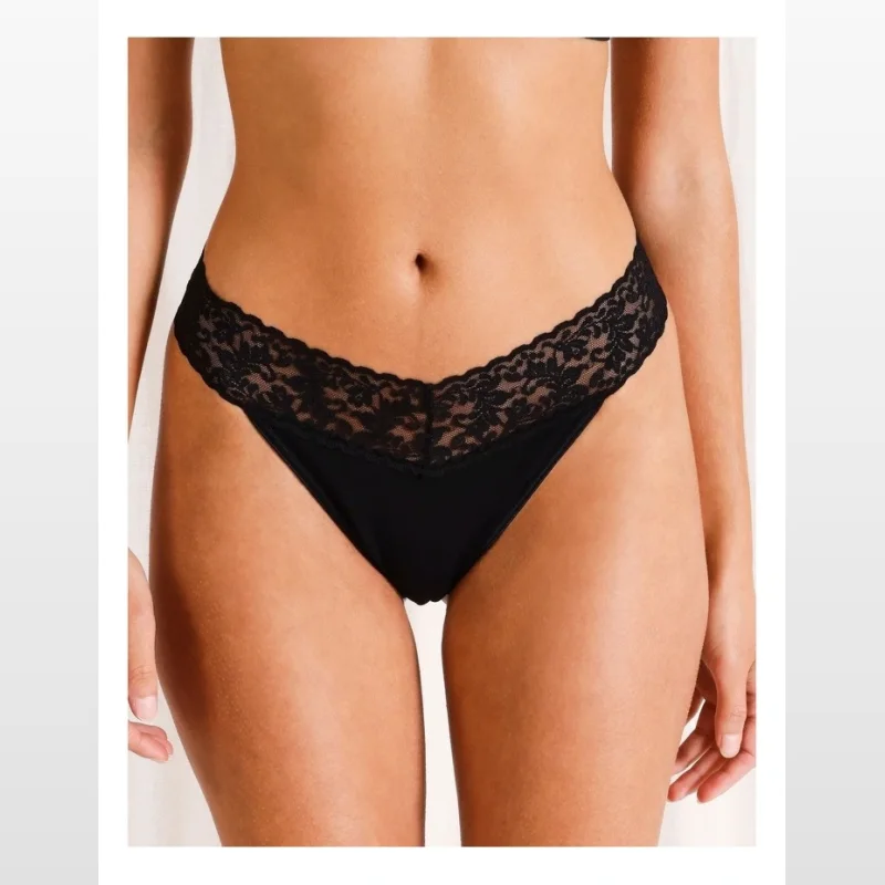Close-up of a woman wearing black cotton and lace g-string briefs.