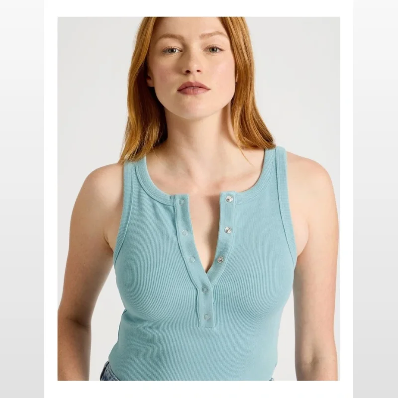 Close-up of a woman wearing a blue ribbed Henley tank top with a button-up neckline.