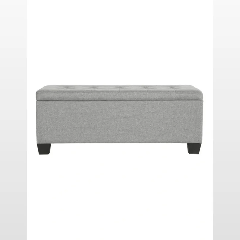 A light grey storage ottoman with a tufted lid and dark square legs, shown from the front.