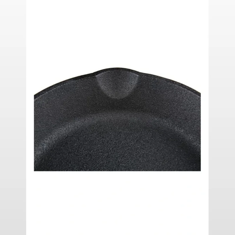 Close-up of the textured black surface of a 20cm cast iron skillet pan.