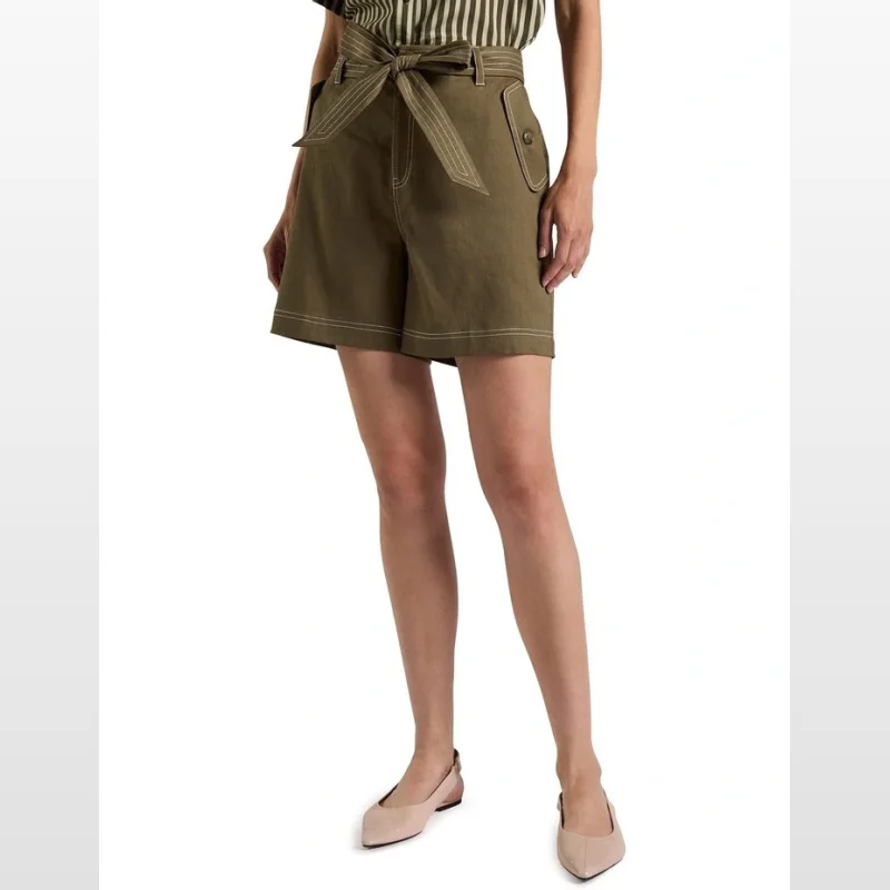 Woman wearing Cabello Stretch Linen Shorts in Moss, featuring a high-rise waist, self-tie belt, and contrast topstitching.