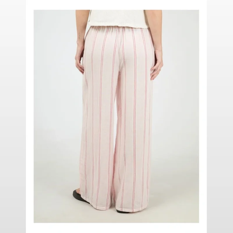 Back view of a woman wearing pink and red striped wide leg pants with an elastic waistband.