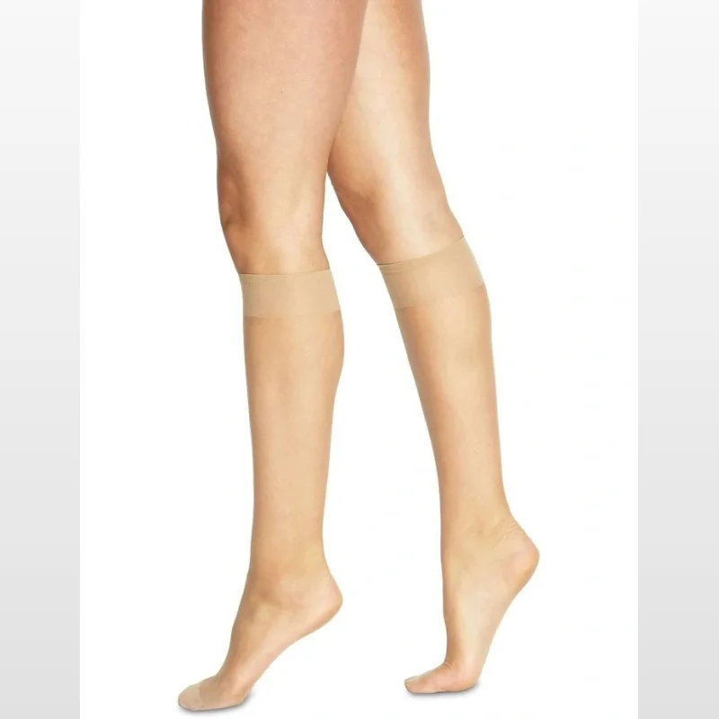Close-up of a woman's legs wearing ultra sheer, nude-coloured knee-high socks with a comfort band at the top.