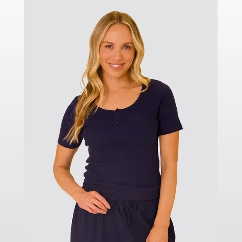 Woman wearing a dark blue ribbed short-sleeve henley sleep tee with a button neckline.