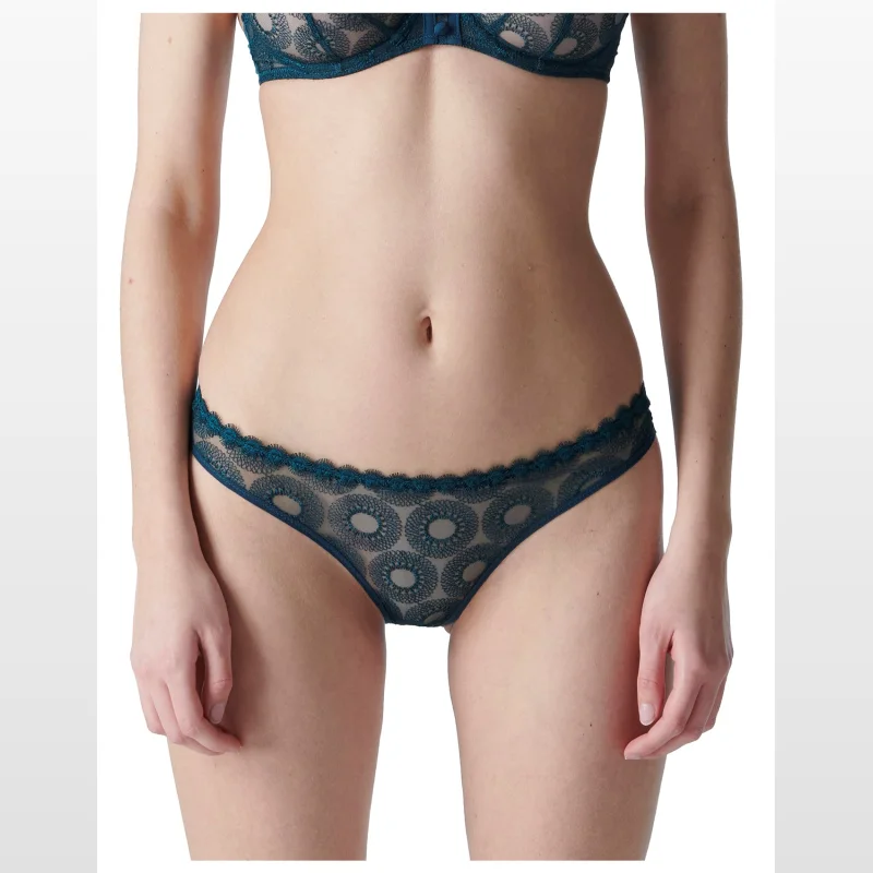 Close-up of a woman wearing a teal Simone Perele Utopia bikini brief with intricate lace detailing and scalloped trim.
