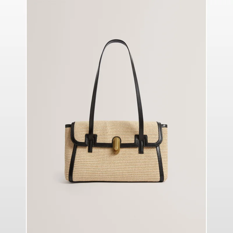 A beige raffia tote bag with black leather trim and straps, featuring a gold-tone twist-lock closure.