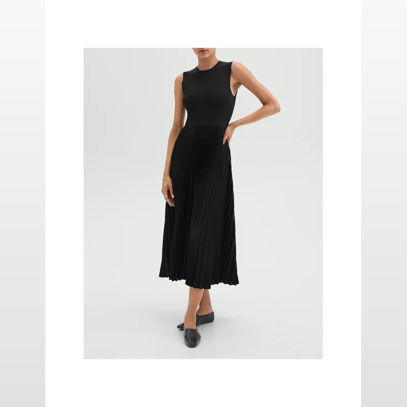 Woman wearing a black sleeveless Theory midi dress with a crewneck and a pleated satin skirt.