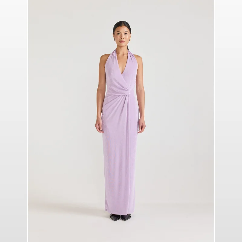 Woman wearing a long, lavender halter neck jersey maxi dress with a gathered waist and plunging neckline.