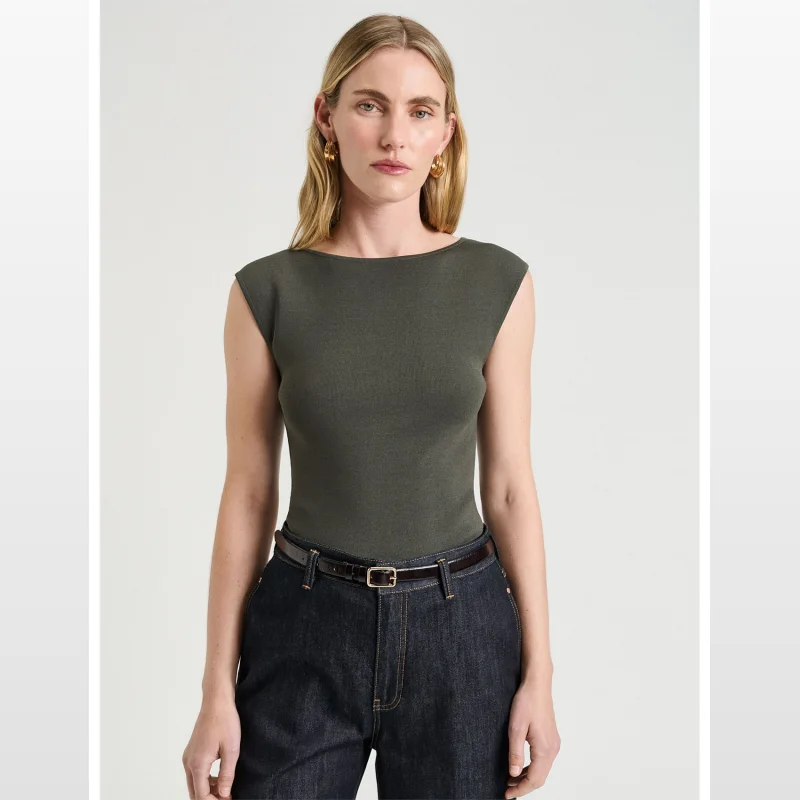 Woman wearing a dark olive green sleeveless knit top with a slash neckline and fitted silhouette.