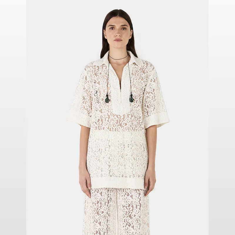 Woman wearing a white lace short-sleeved Hansen & Gretel Marlow Lace Top with a relaxed fit and dropped shoulders.