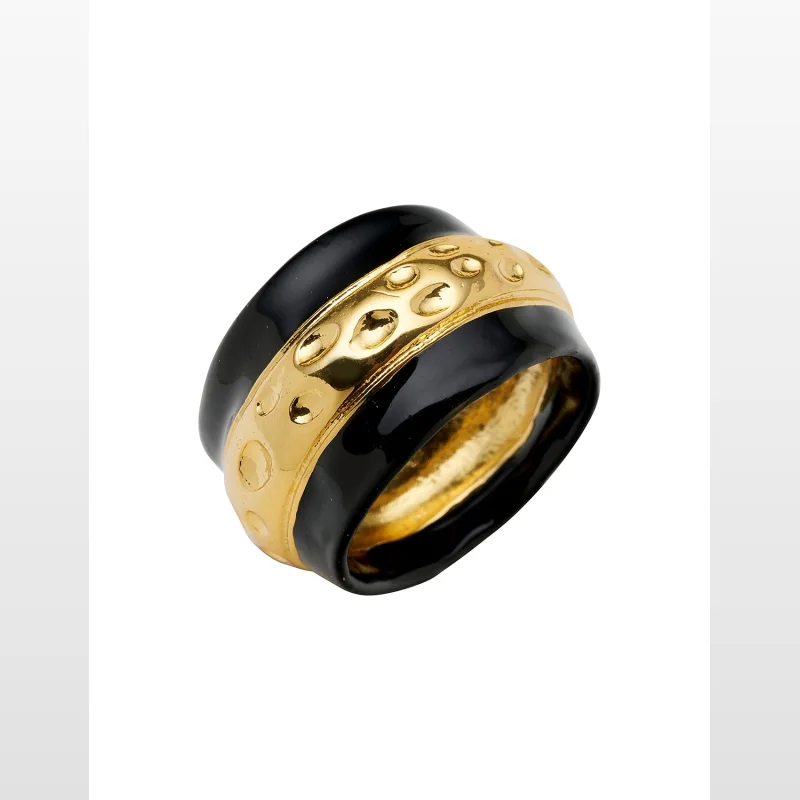 A close-up shot of a David Lawrence Solid Mine Ring, featuring a gold-coloured band with a hammered texture and black enamel borders.