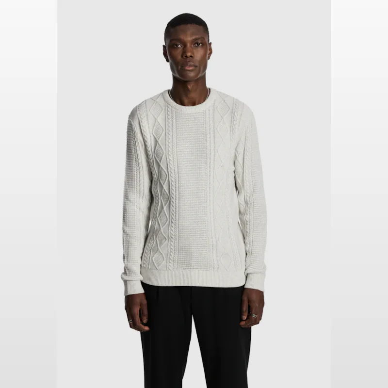 Man wearing an ice grey cable knit crew neck jumper with textured panels.