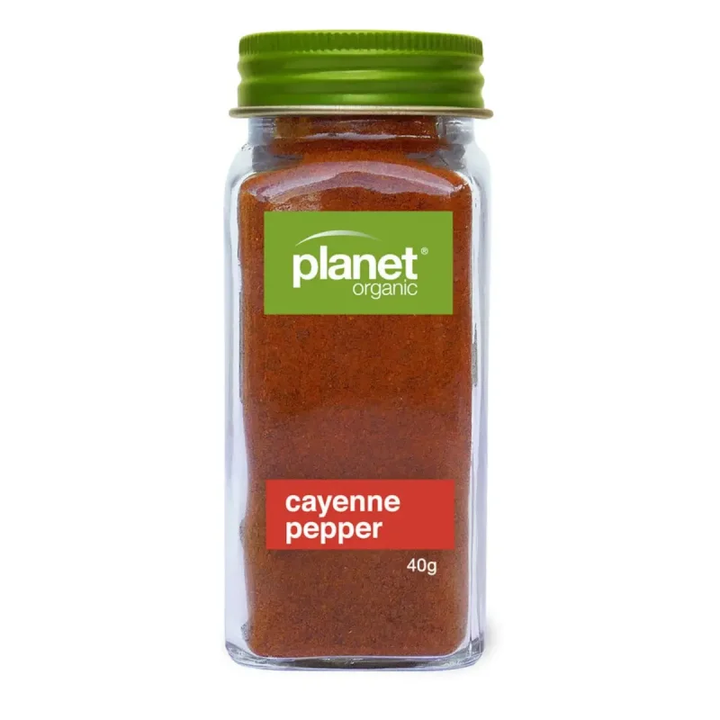 A glass jar of Planet Organic Cayenne Pepper, showing the green lid and label with the product name and weight.