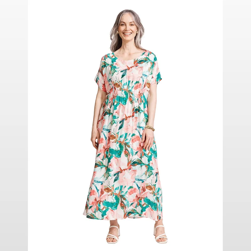 Woman wearing a white midi dress with a painterly floral print in shades of pink, teal, and brown, featuring short sleeves and an elasticated waist.