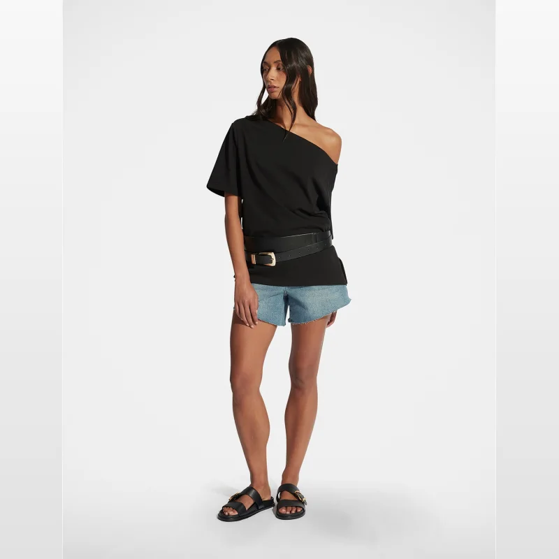 Model wearing DECJUBA Kylie High Rise Raw Hem Denim Shorts with a black off-the-shoulder top and black sandals.