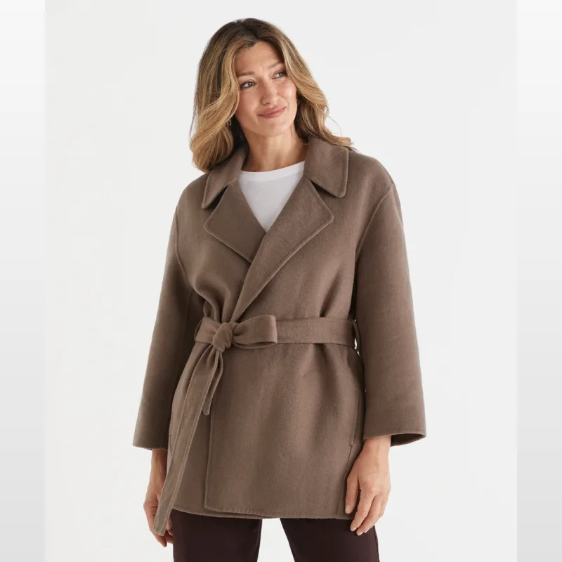 Woman wearing a brown midi wrap coat with a self-tie belt and tailored collar.