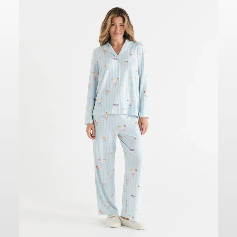 Woman wearing a light blue striped long sleeve pyjama set with a repeating pattern of martinis.