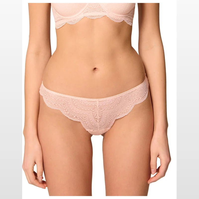 Close-up of a woman wearing a pale pink Simone Pérèle Karma Tanga brief, showcasing the intricate Italian Jacquard lace with scalloped trimming.