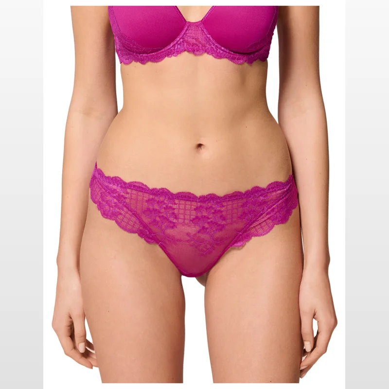 Close-up of a woman wearing a magenta Simone Perele Reve Tanga g-string with scalloped lace trim on the waist and back.