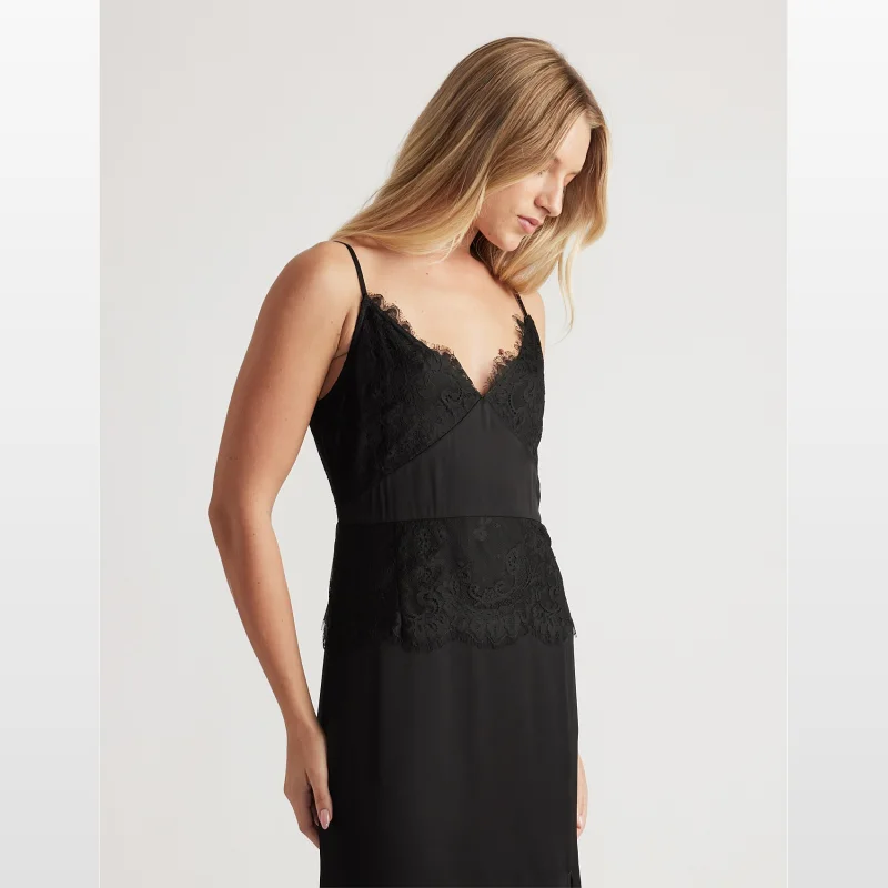Woman wearing a black lace maxi dress with thin adjustable straps and a V-neckline.