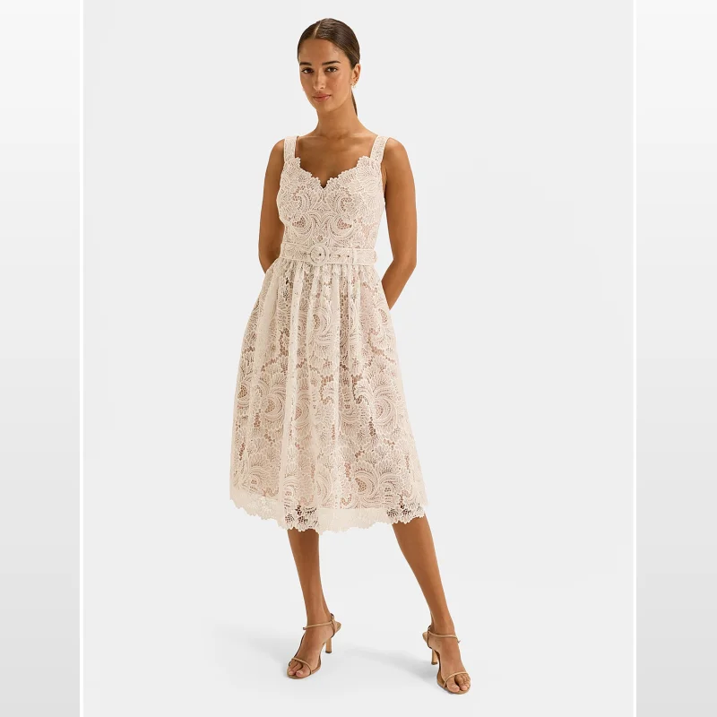 Woman wearing a sleeveless, ivory lace midi dress with a V-neckline, a matching belt, and a flared skirt. The dress has a structured bodice and a scalloped hem.