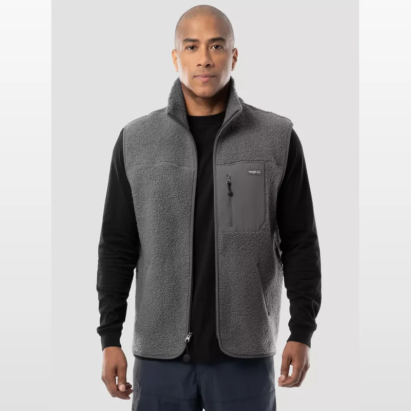Man wearing a grey Wrangler ATG Sherpa Utility Hiking Vest over a black long-sleeved shirt.