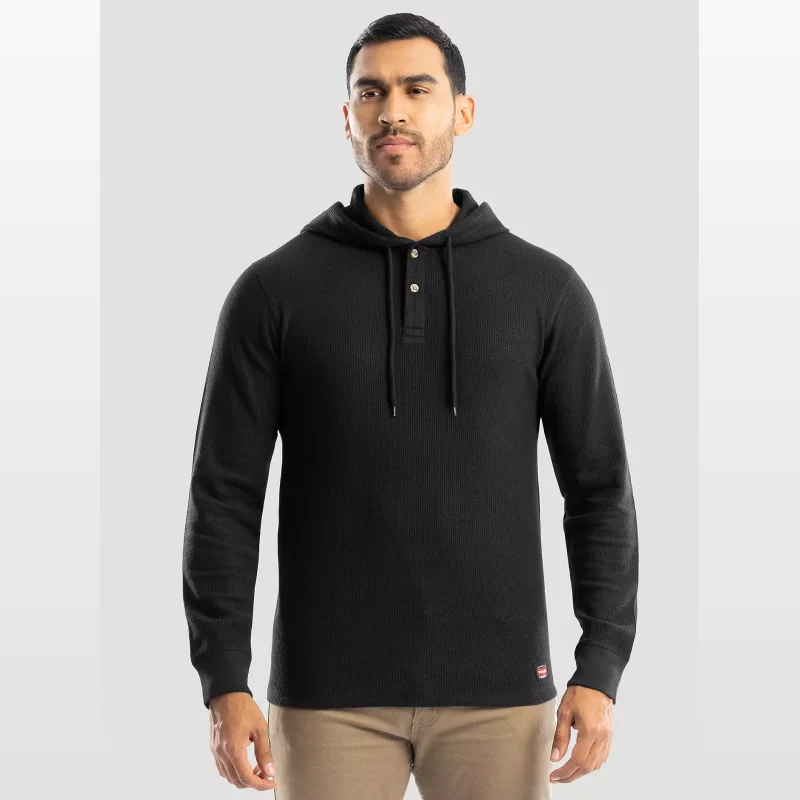 Man wearing a black long-sleeved hooded waffle knit henley shirt with a two-button placket and drawstring hood.