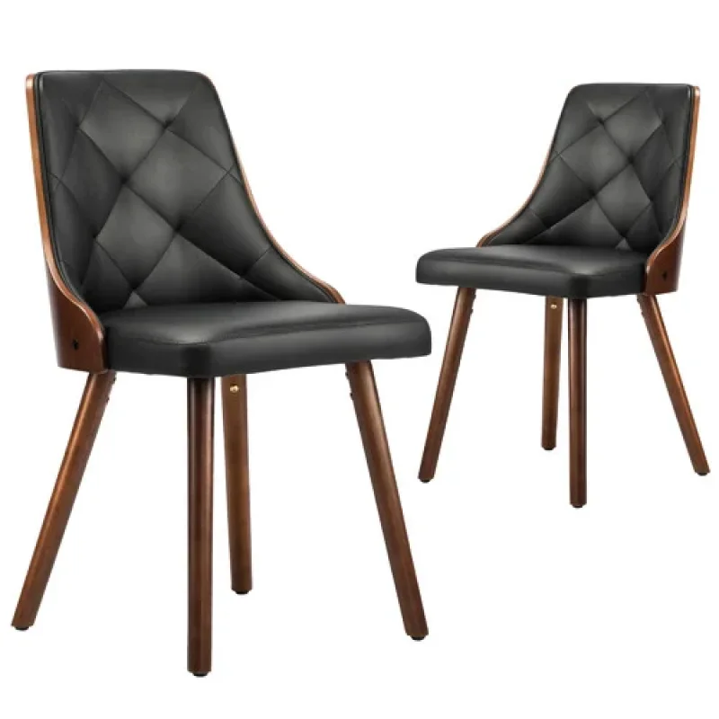 Two black faux leather dining chairs with diamond tufting and curved wooden frames and legs.