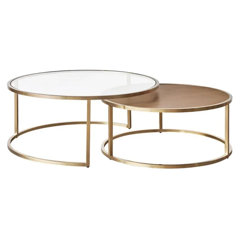A set of two round nesting coffee tables with gold metal frames. One table has a clear glass top, and the other has a wood-effect top.
