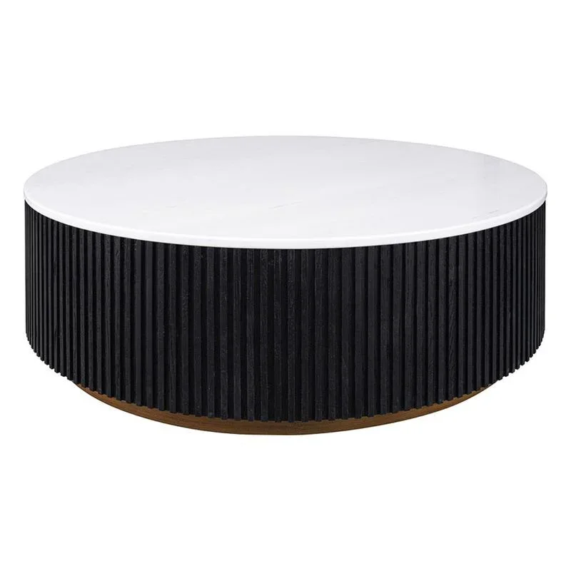 A round coffee table with a white top and a black fluted base, sitting on a light wood plinth.