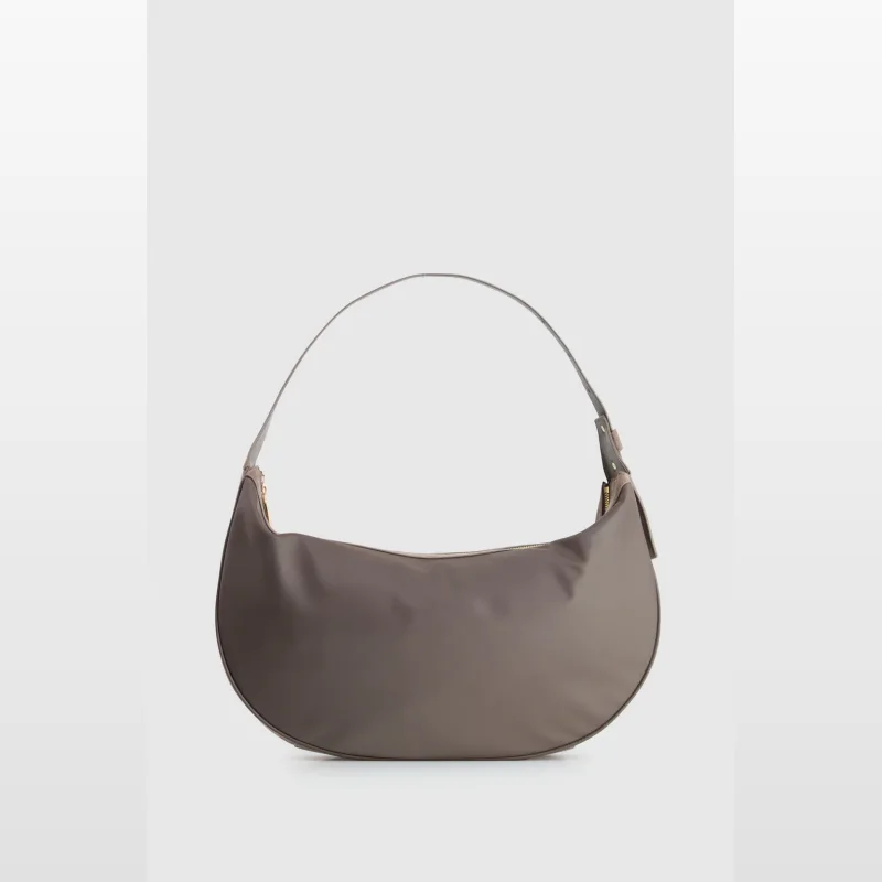 A taupe Noemie medium shoulder bag with a curved shape and a single adjustable strap.