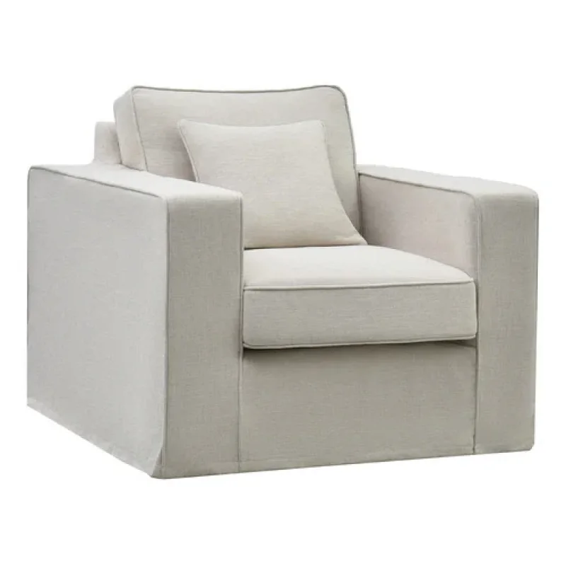 A light-coloured slipcover armchair with a square cushion on the seat and a smaller square cushion on the back.