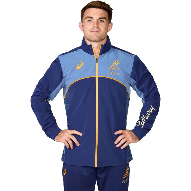 Man wearing a blue and light blue Wallabies Lions Tour 2025 team tech jacket with yellow trim and Cadbury branding.