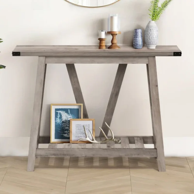 A grey wooden two-tier console table with decorative items on its surfaces.