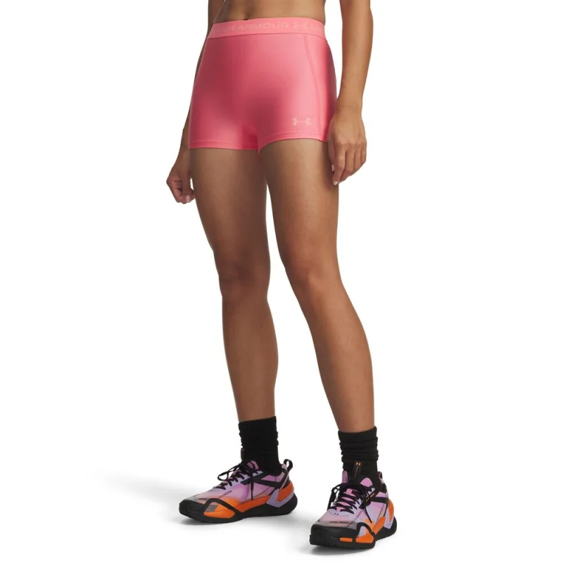 Woman wearing pink Under Armour HeatGear shorty bike tights with black socks and colourful athletic shoes.