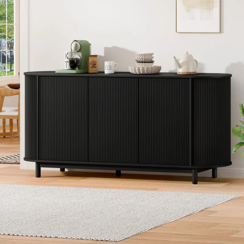 A black three-door sideboard buffet with a fluted design and black legs, shown in a modern interior setting with decorative items on top.