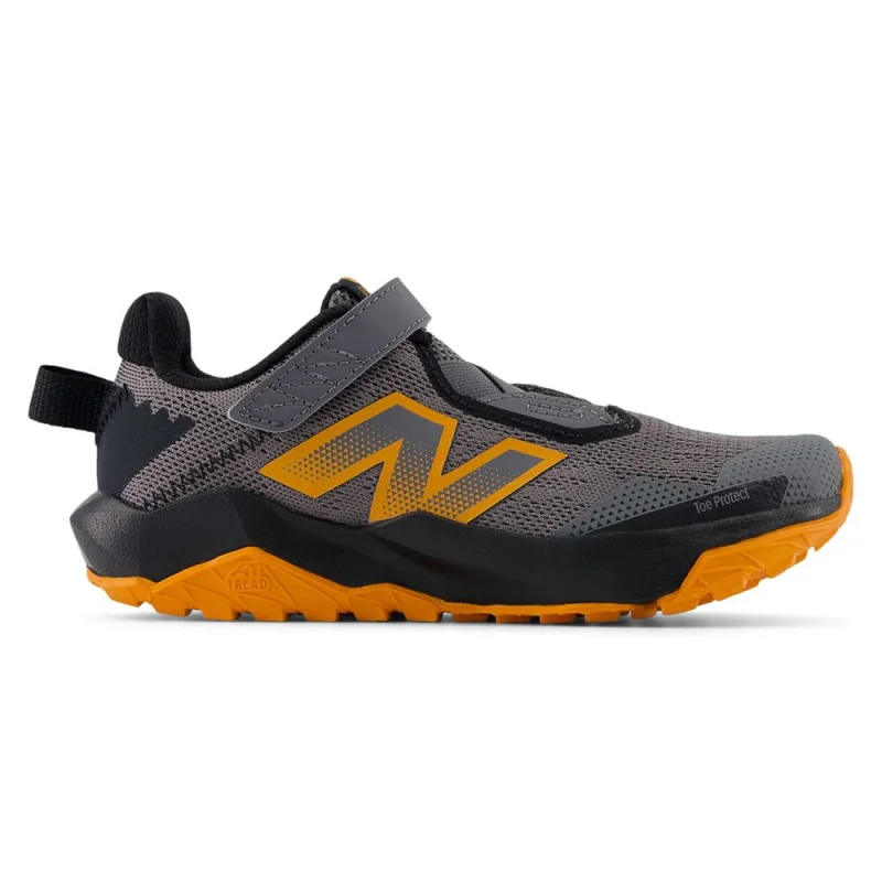 Side view of a New Balance Nitrel V6 PS kids' trail running shoe in grey and orange, featuring a mesh upper, velcro strap, and a rugged orange outsole.