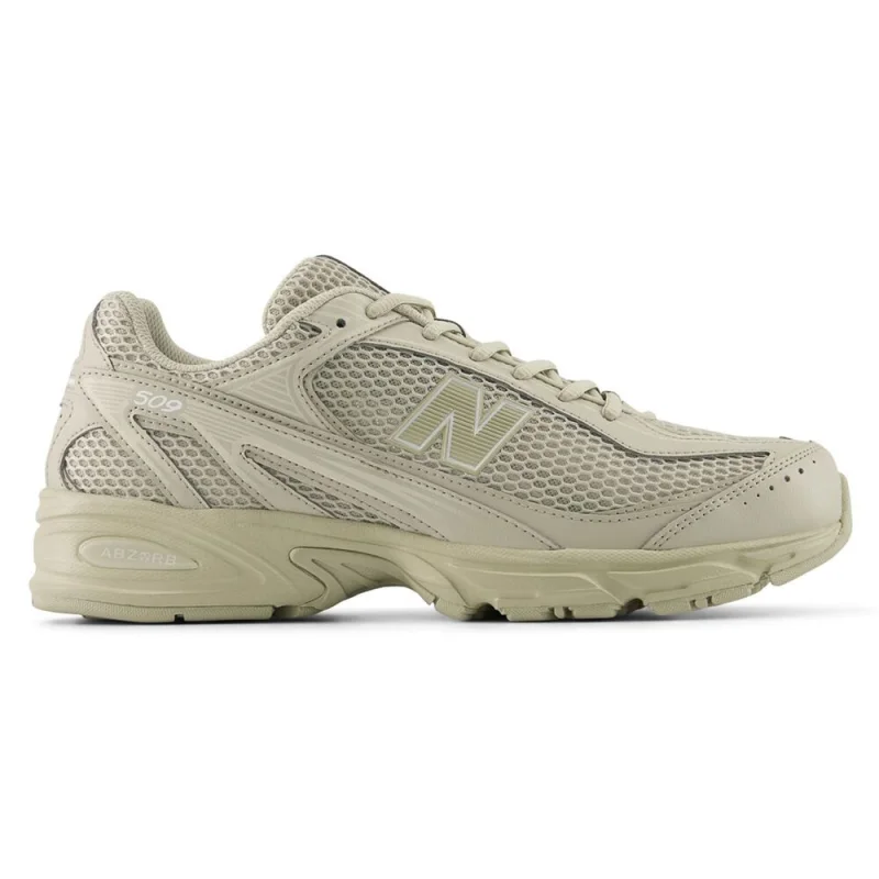 Side view of a New Balance 509 casual shoe in a light beige colour, featuring a mesh upper, synthetic overlays, and an ABZORB midsole.