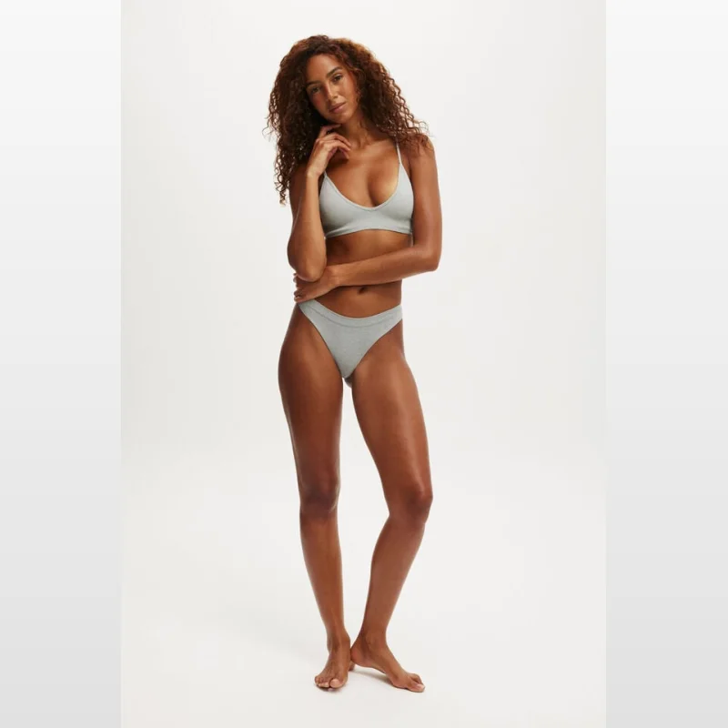 Woman wearing a grey seamless hipster cheeky brief and matching bralette.