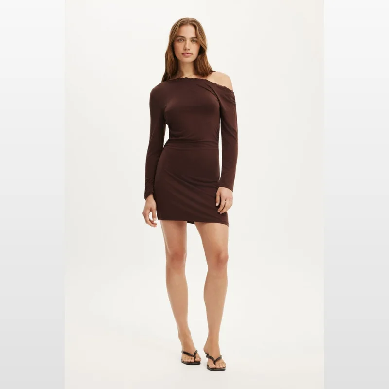 Woman wearing a brown long-sleeved asymmetrical mini dress with off-shoulder detail and lace trim.
