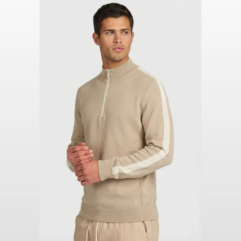 Man wearing a beige Academybrand Danzer 1/4 Zip knit jumper with white stripes on the sleeves.
